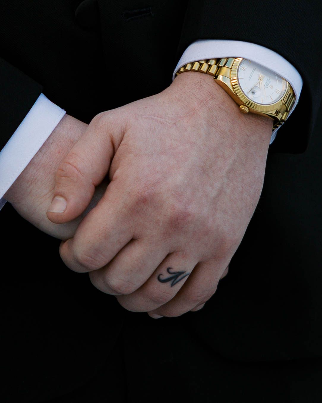 Close-up detail shots of hands wearing gold jewelry and watches.