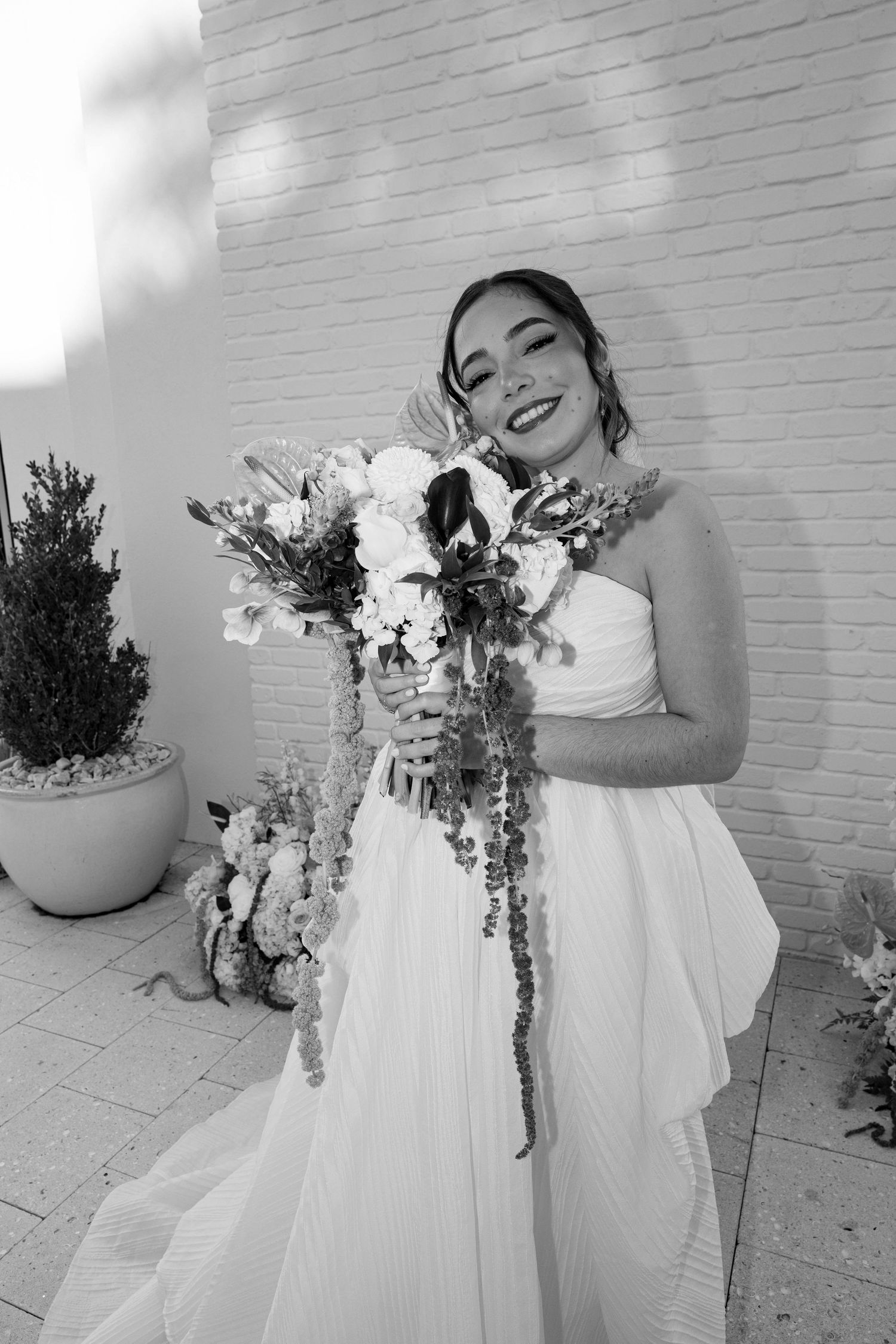 Black and white wedding photography series showcasing bridal details and floral arrangements.