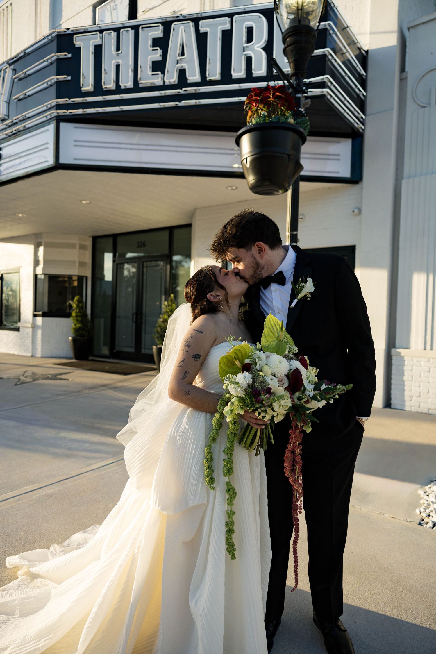 Intimate wedding moment captured under the vintage theater marquee.