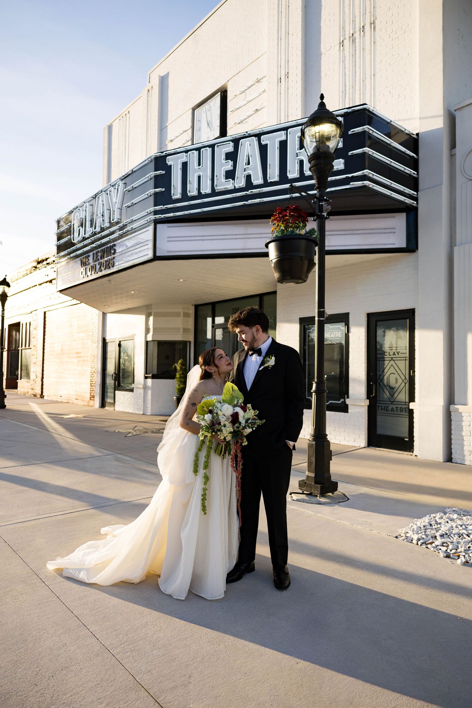 Couple poses for wedding photos in front of the Clay Theatre's vintage marquee.