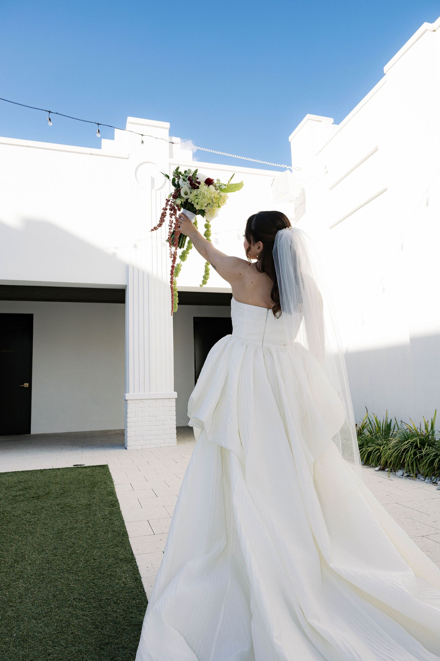 Ethereal bridal portraits in an all-white modern architectural setting with outdoor elements.