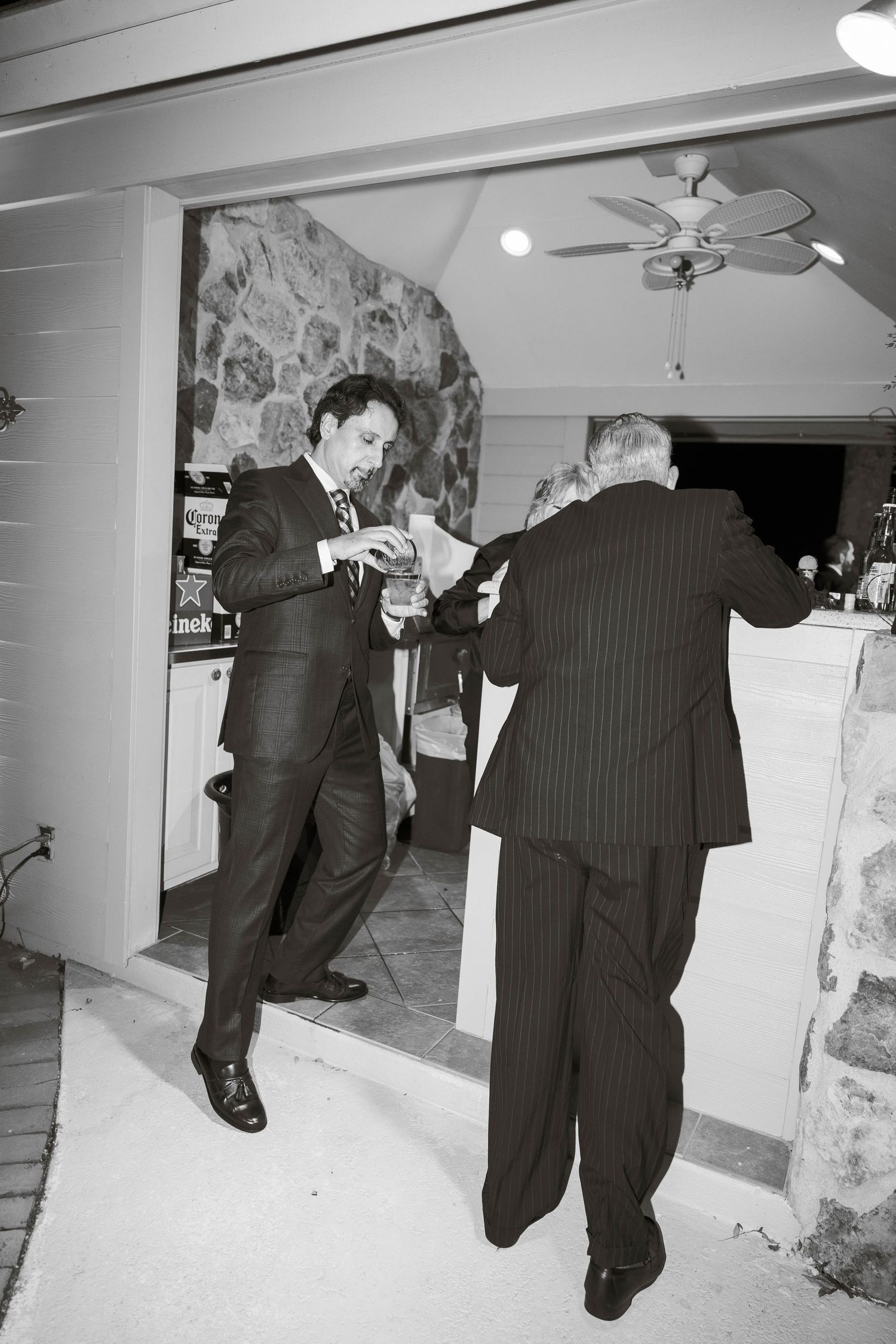Black and white photos of two people in suits dancing playfully.