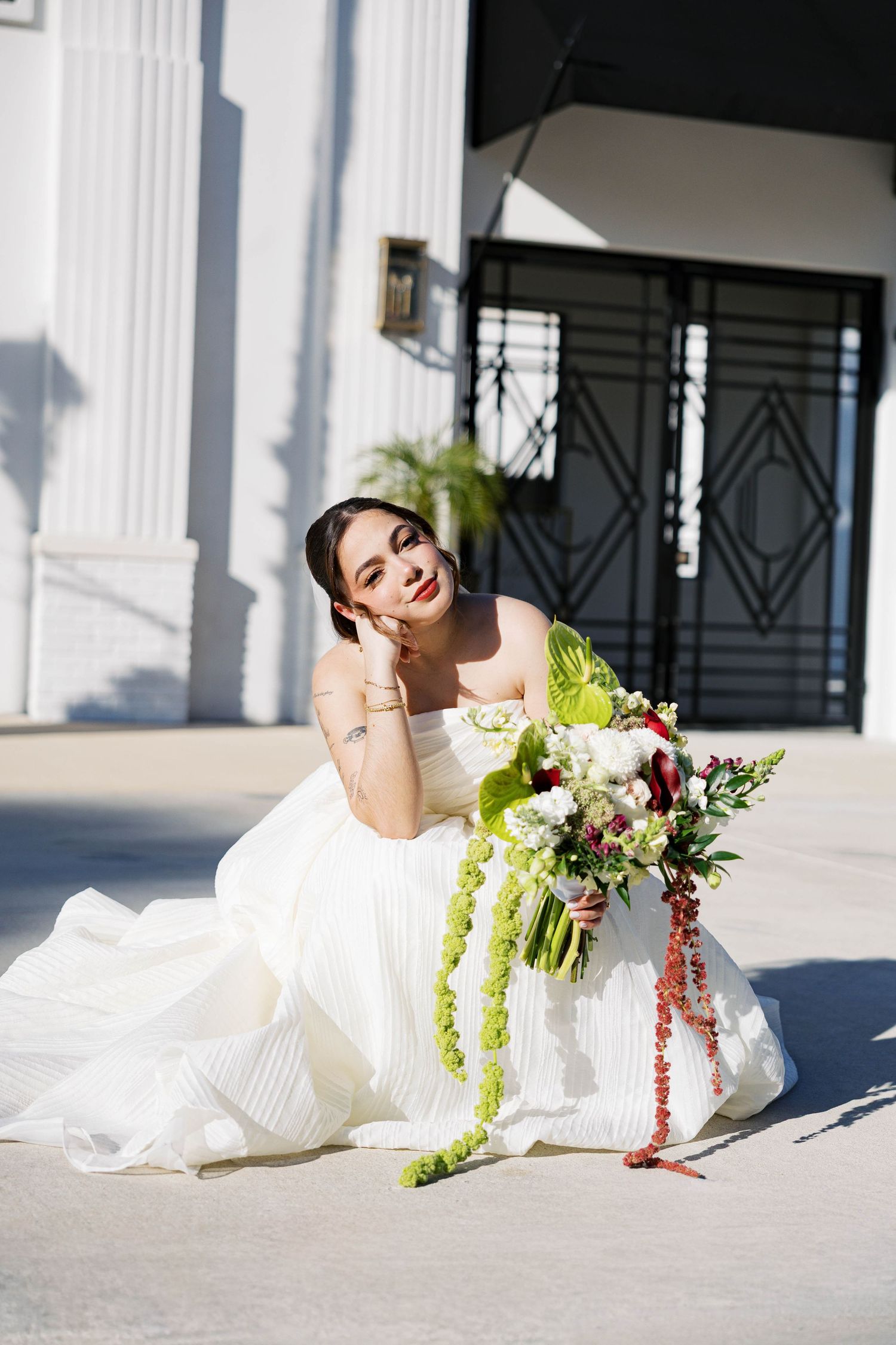 Bridal portrait session outside the Clay Theatre featuring a white gown and colorful bouquet.