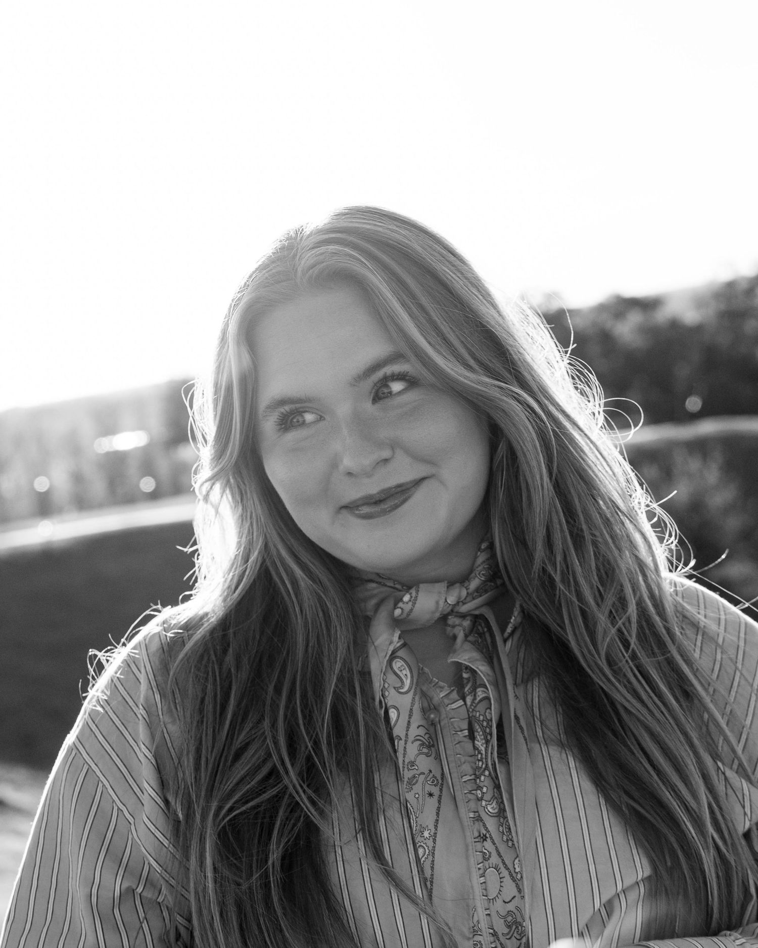 Black and white portrait series showing a person with long hair expressing different emotions outdoors.