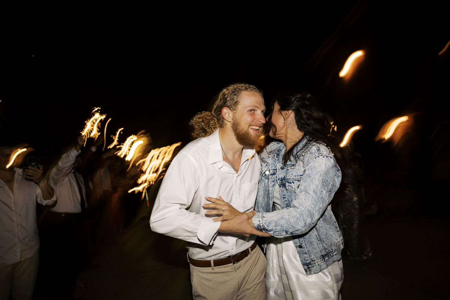 A romantic first dance at a wedding reception with guests watching in a dimly lit venue.