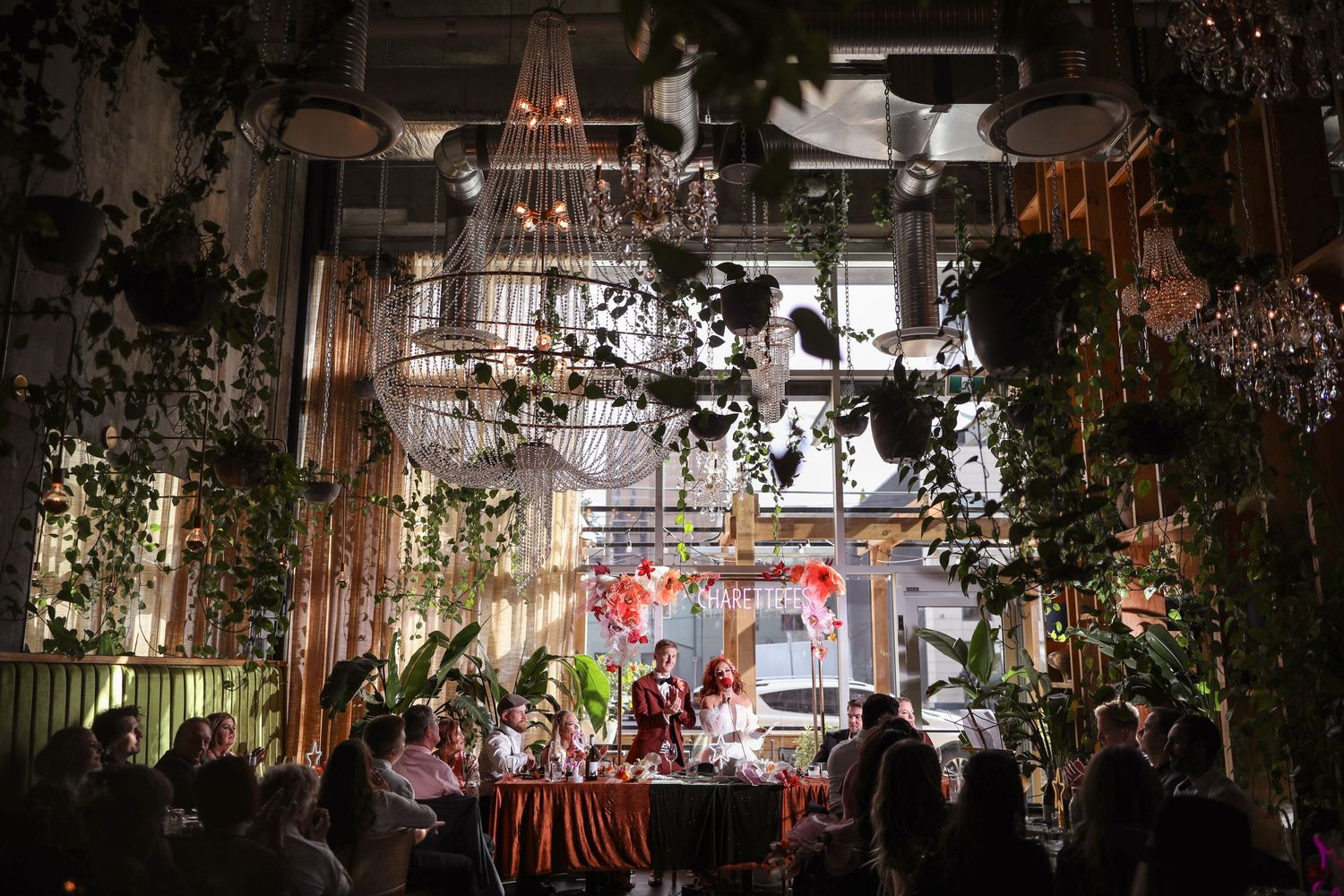 Elegant wedding reception venue decorated with hanging chandeliers and greenery at Calgary's downtown Orchard Restaurant.
