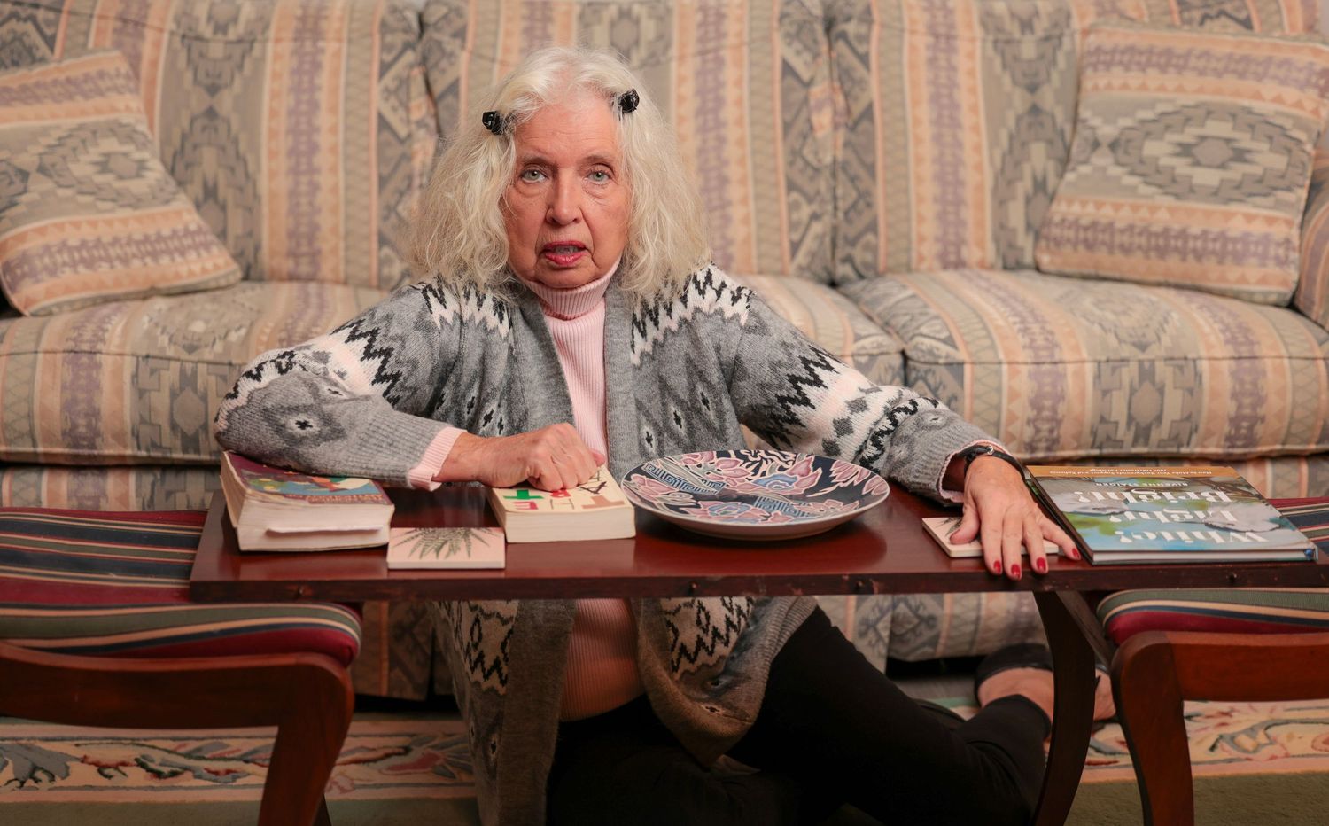 Candid shots showing animated gestures while seated on a patterned couch with coffee table.