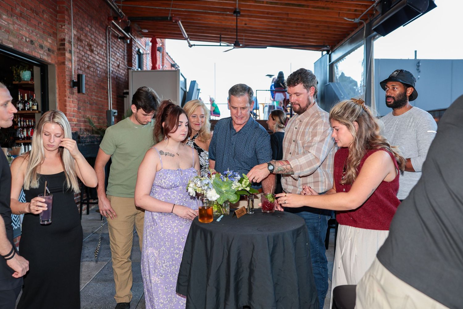 Celebration guests mingling in an urban venue with exposed brick and natural lighting.