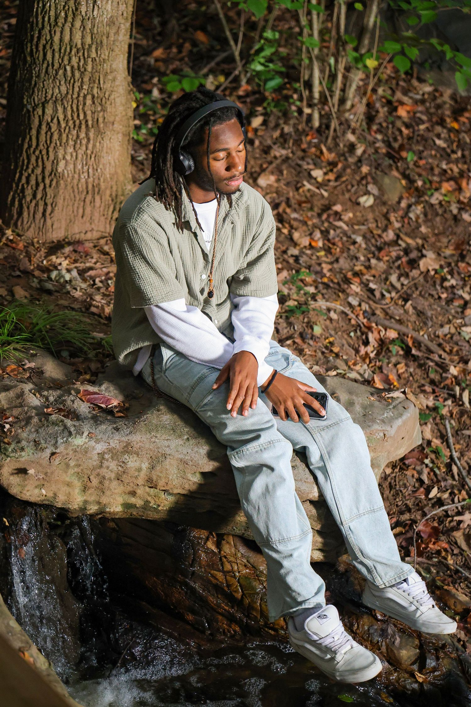 Artistic photoshoot on a fallen tree trunk in a forest setting.