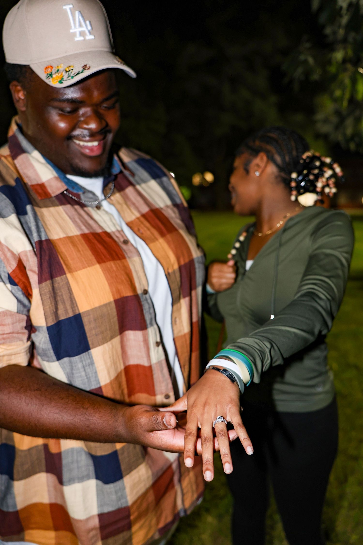 A joyful moment showing off an engagement ring during a nighttime proposal.
