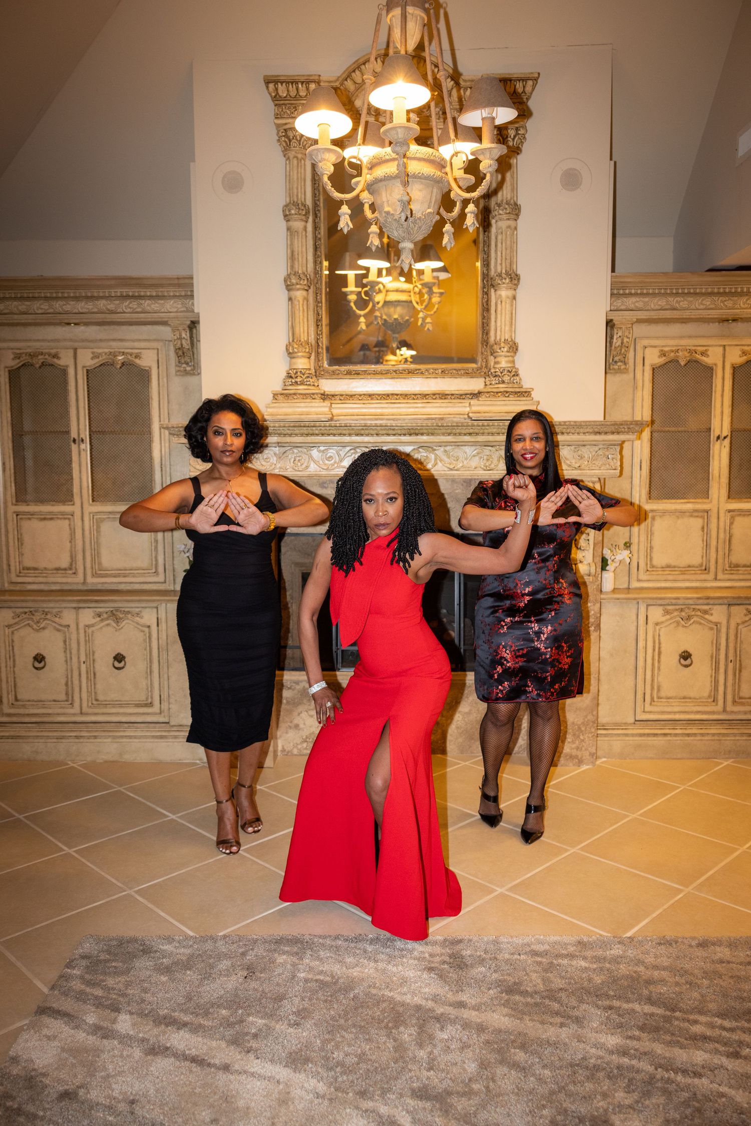 A group poses in elegant attire against an ornate backdrop with decorative wall panels.