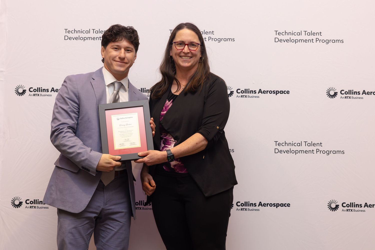 Two professionals pose with an award plaque at Collins Aerospace Technical Talent Development Programs event.