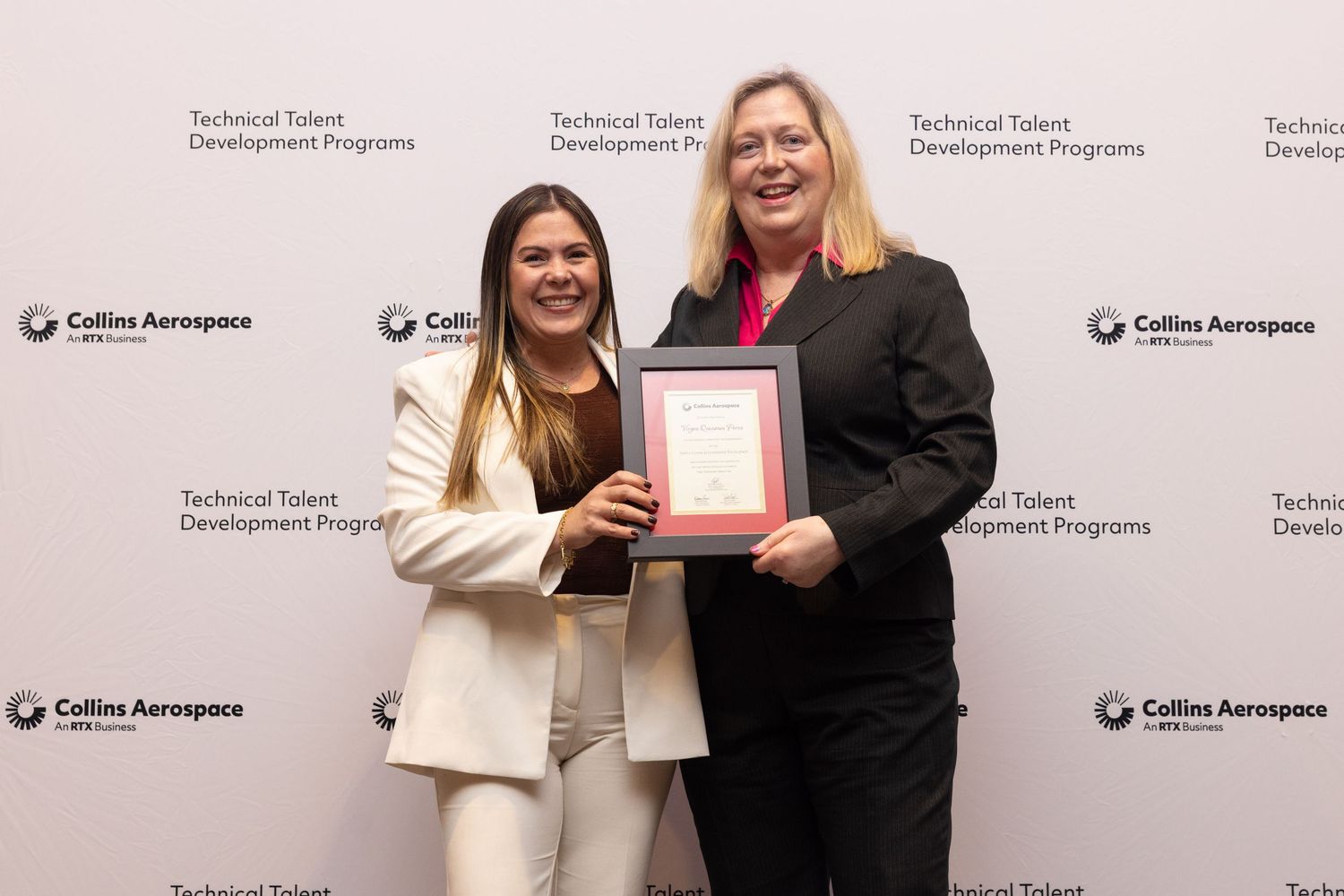 Two women pose with a framed award at Collins Aerospace Technical Talent Development Programs ceremony.