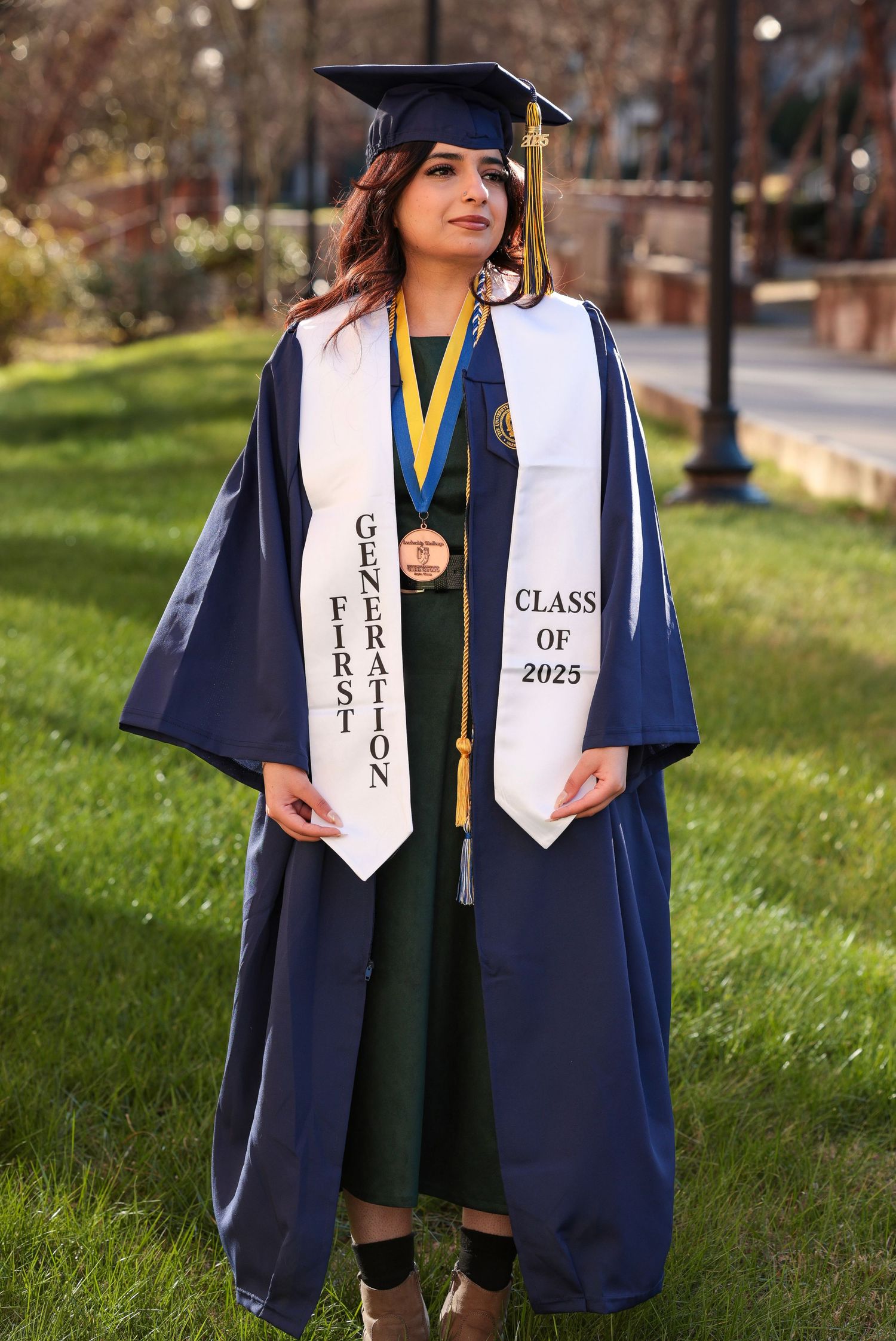 Close-up of graduation attire showing Class of 2023 sash and decorative stoles against navy gown.