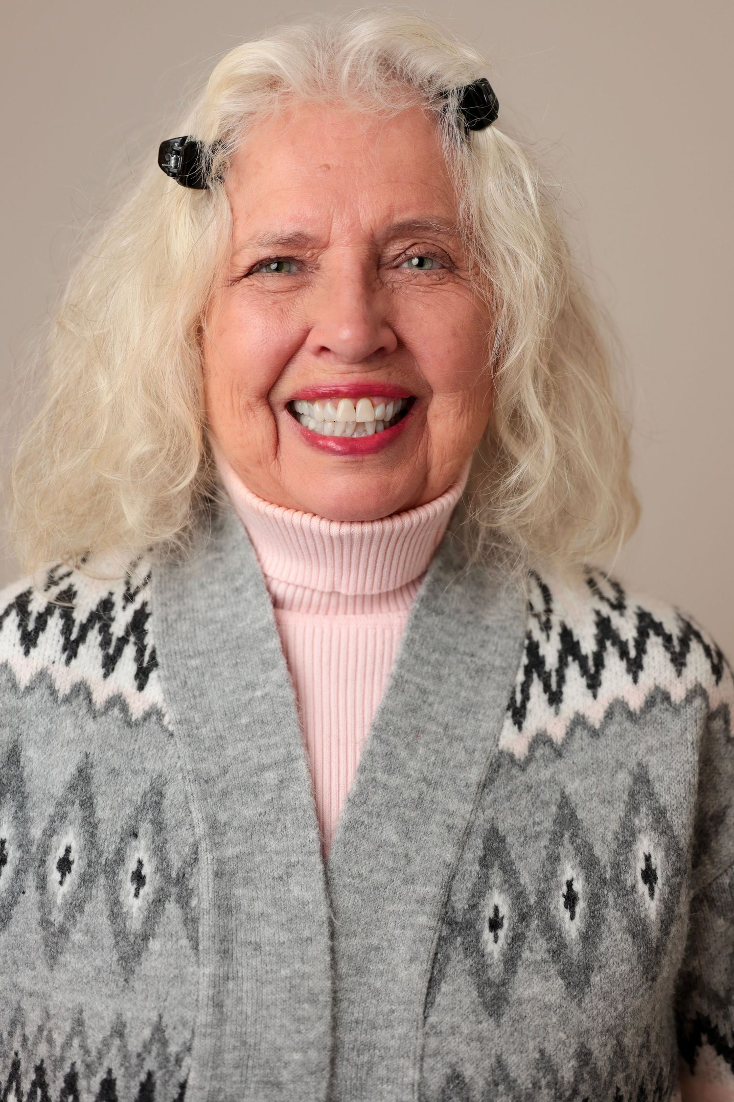 Studio portrait featuring warm winter attire with geometric patterned gray sweater.