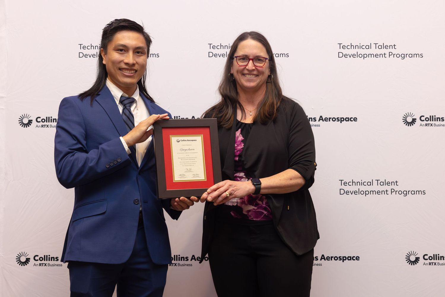 Two professionals pose with a framed award at Collins Aerospace Technical Talent Development Programs ceremony.