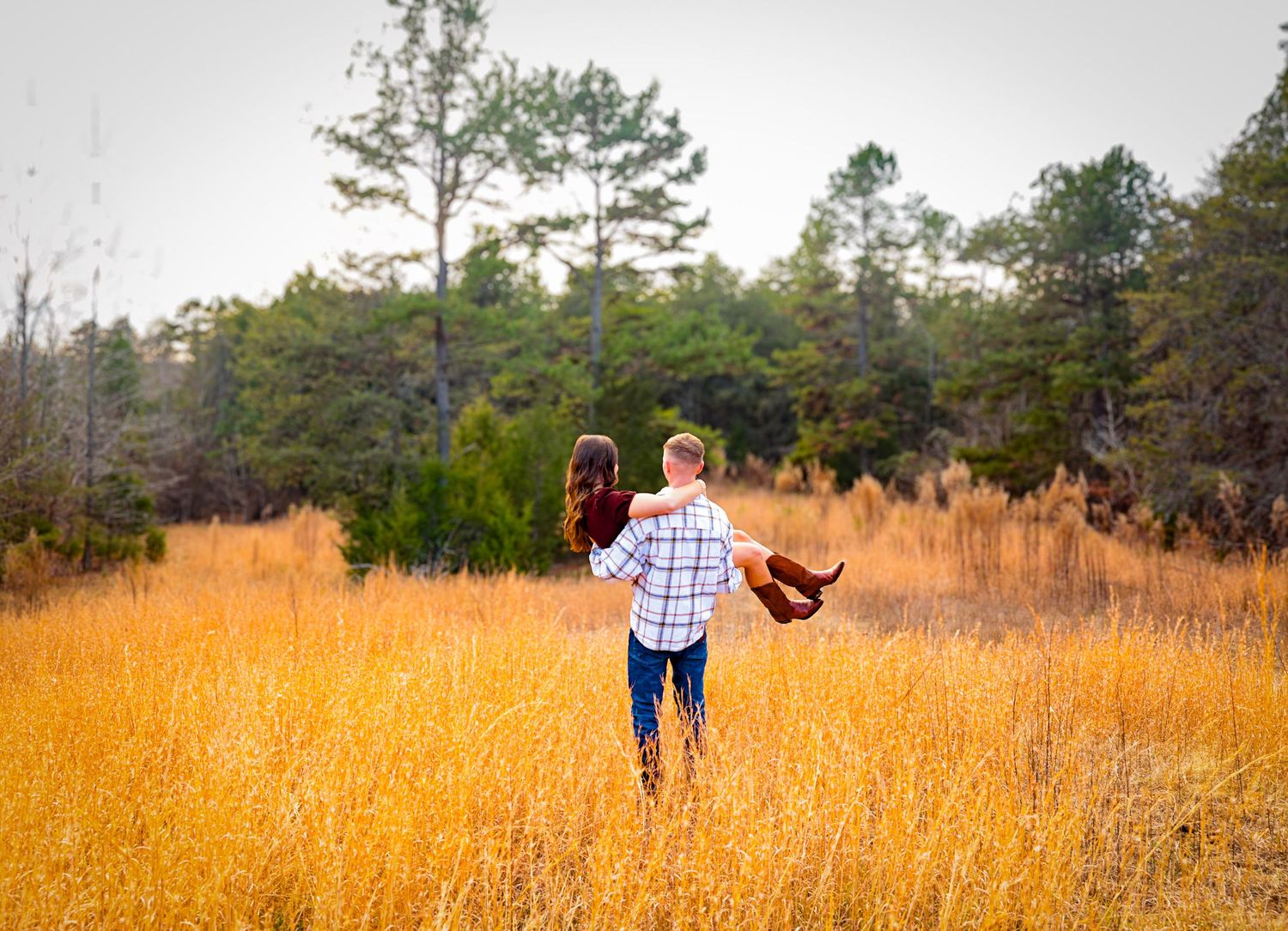 Panoramic view of people walking through a golden wheat field during sunset.