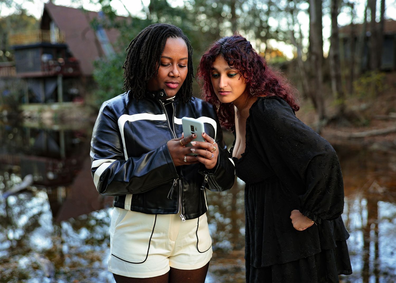 People taking selfies and sharing moments in a forest setting at dusk.