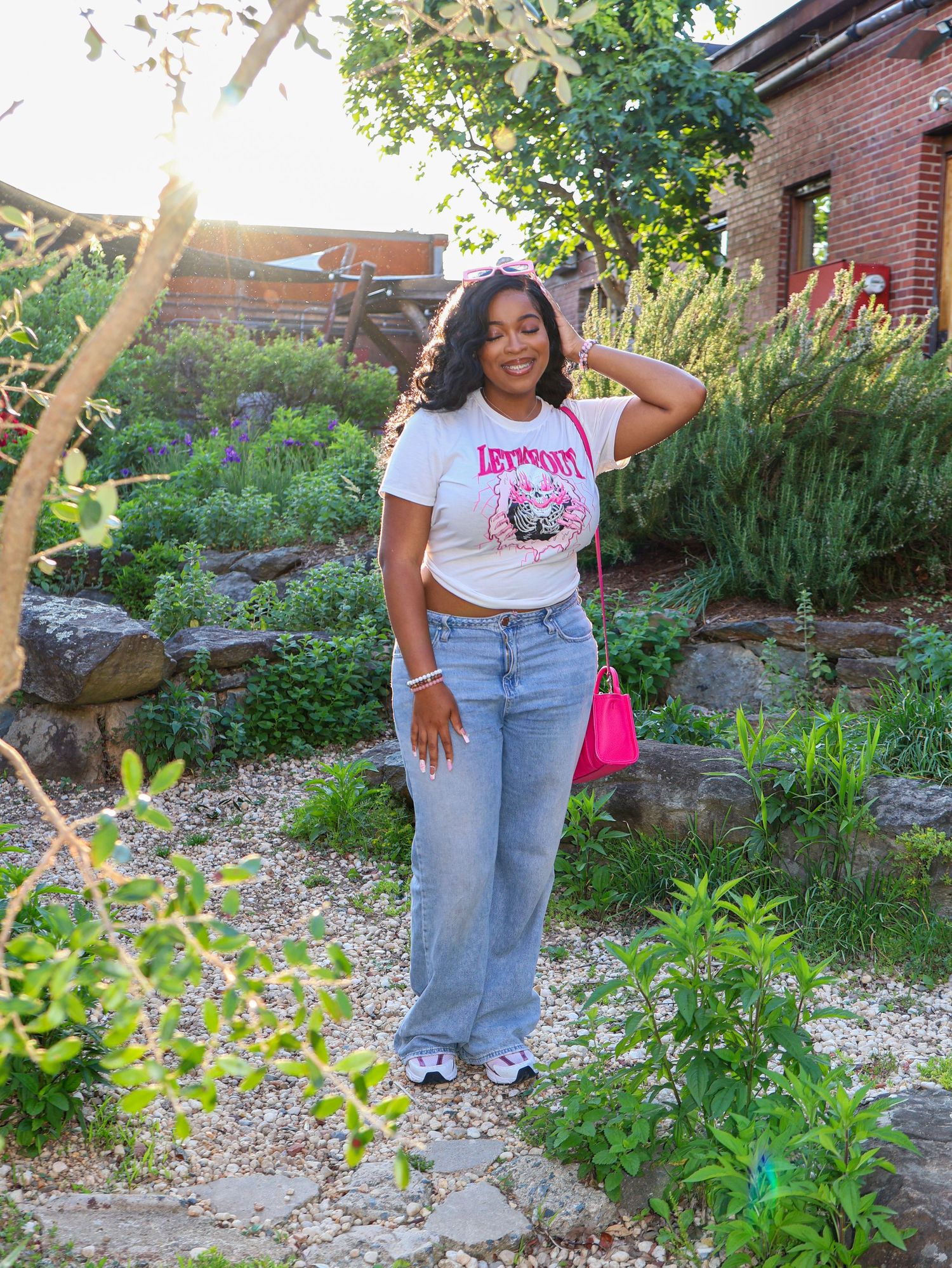 Casual outdoor portrait session in landscaped garden with brick architecture.