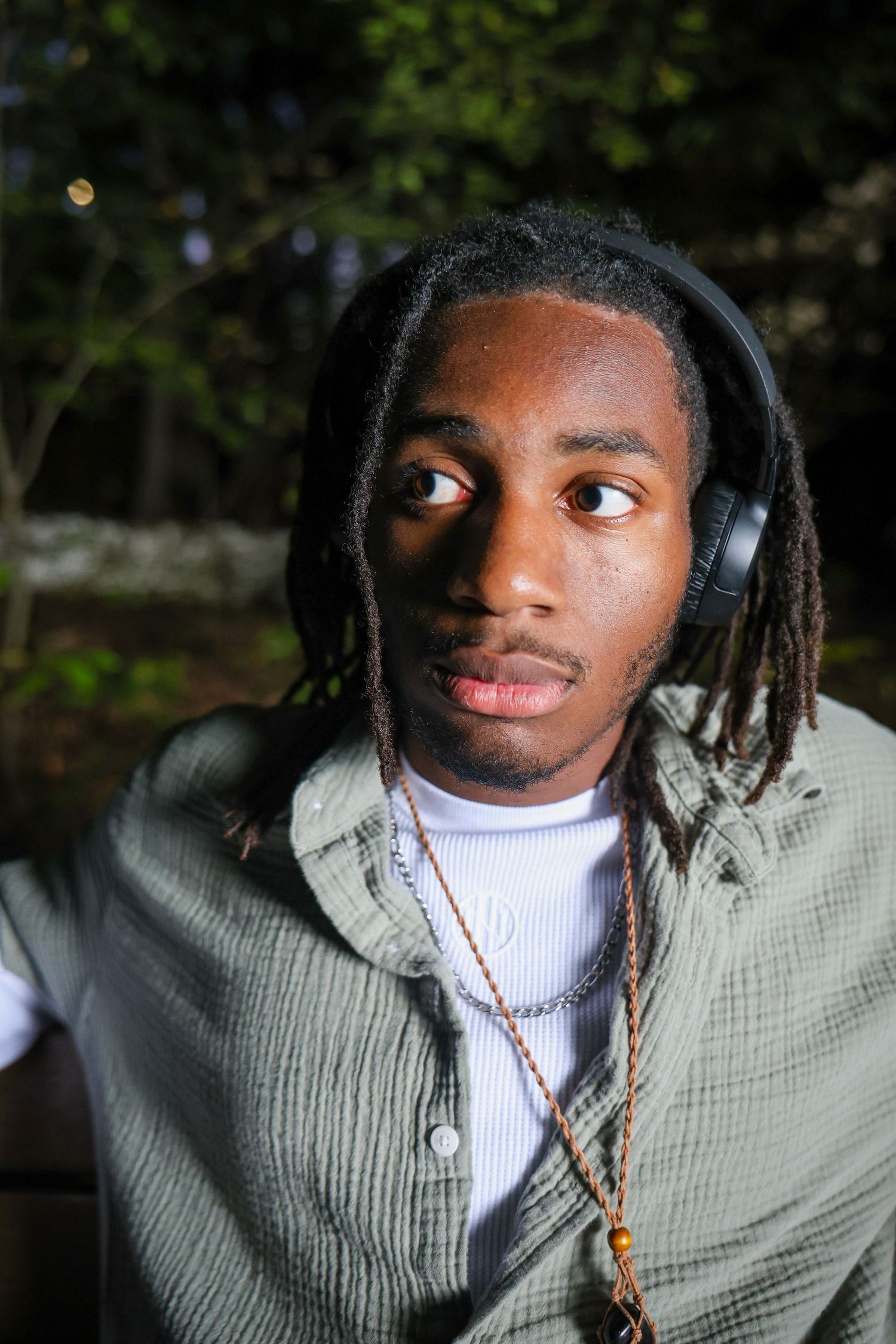 Portrait series showing different expressions and angles against a dark outdoor background.