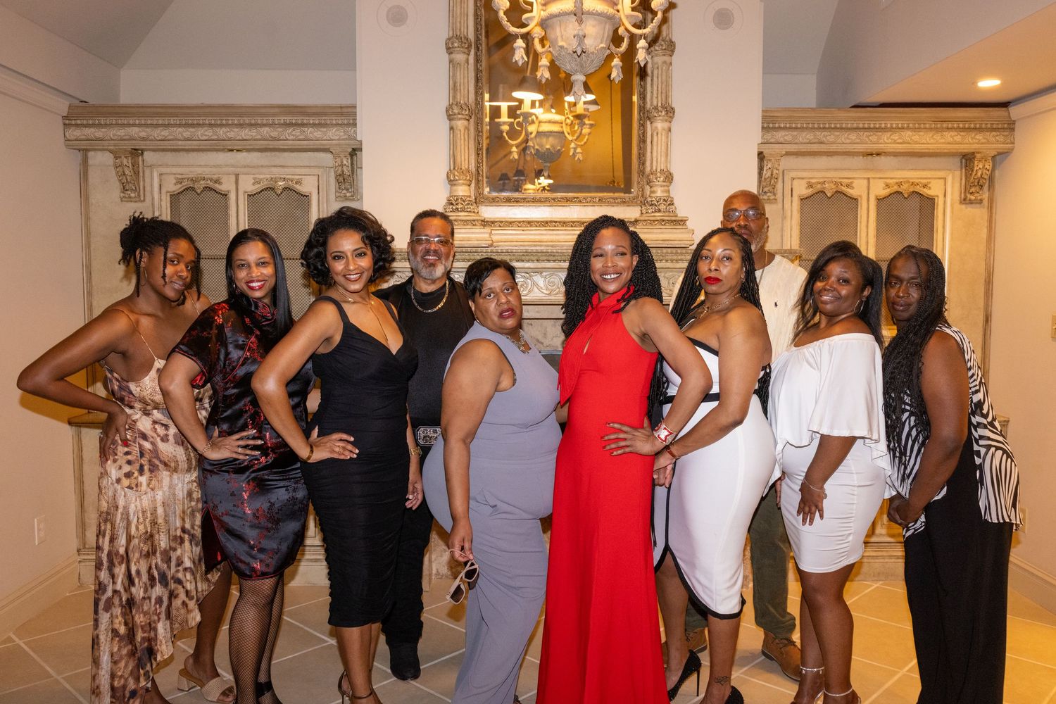 People posing together at an upscale social event in an ornate hallway with decorative wall details.