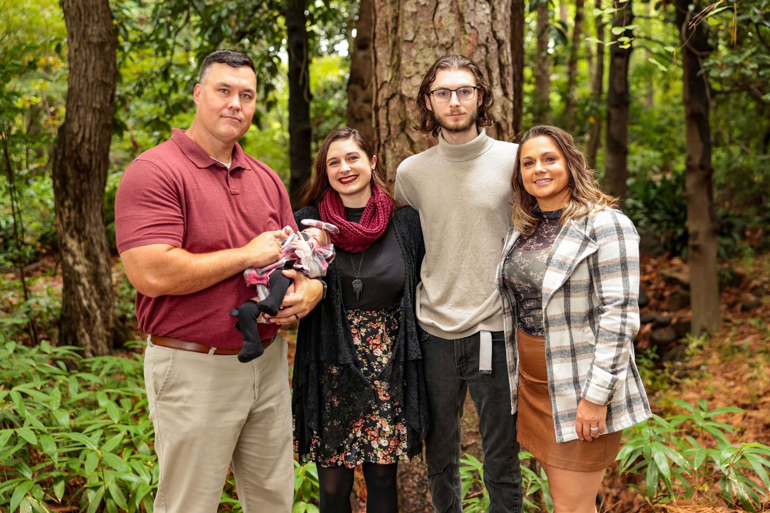 Group photo session on a wooded trail with people wearing coordinated casual outfits.