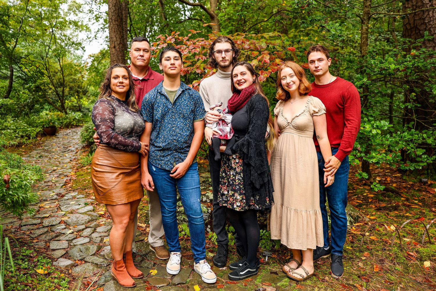 Outdoor group photography session with people arranged along a forest pathway.