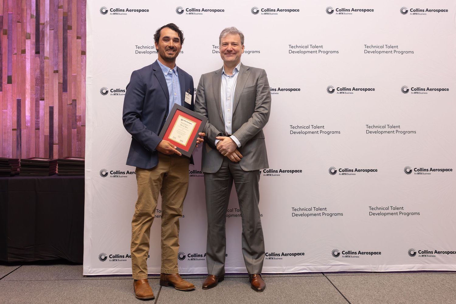 Two professionals pose with an award at Collins Aerospace Technical Talent Development Program ceremony.