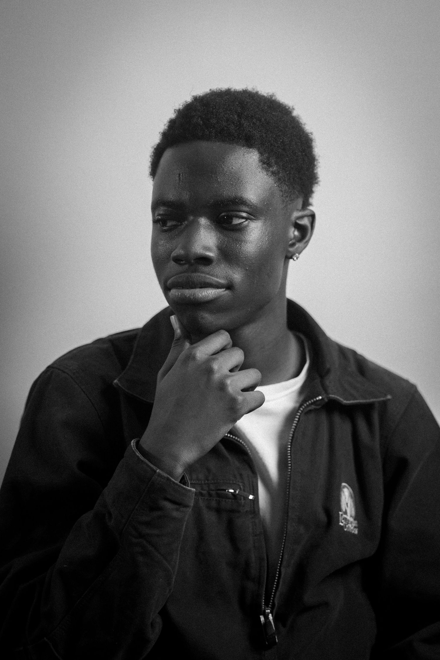 Black and white portrait showing contemplative expressions in dramatic lighting.