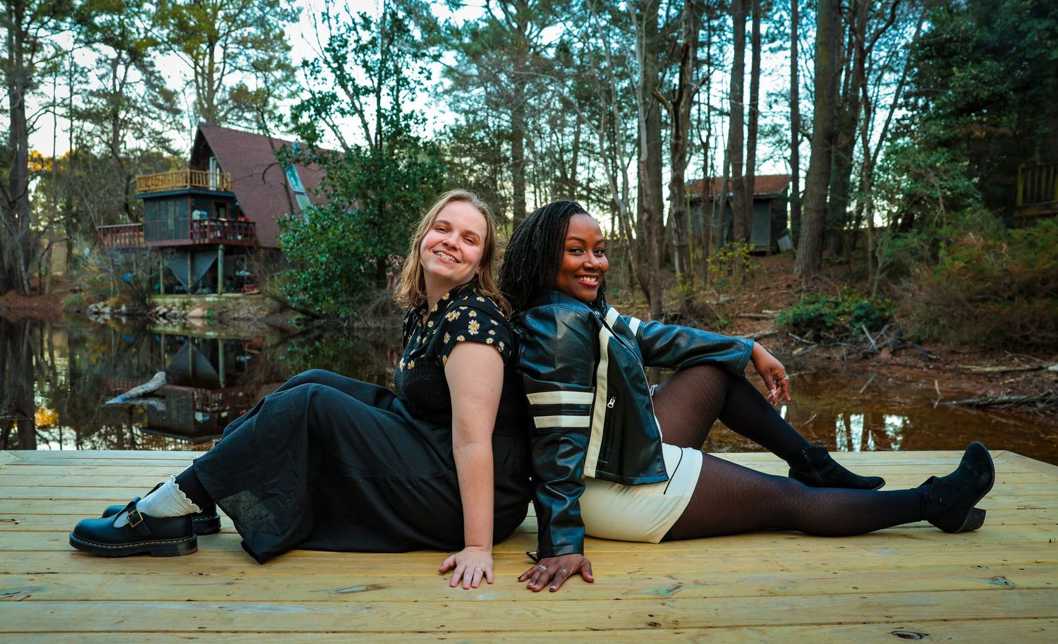 Friends lying down and posing playfully on a wooden deck.