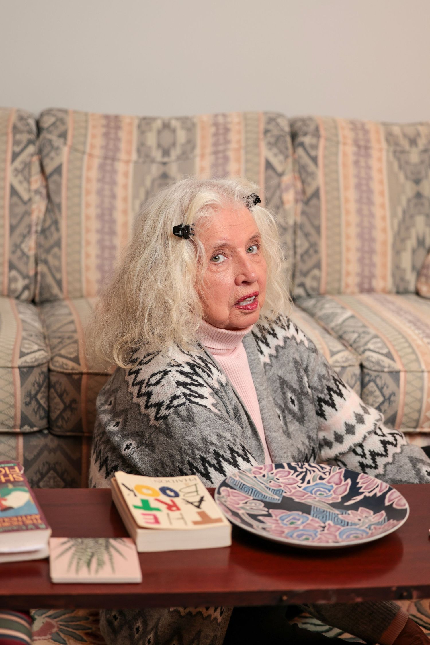 Series of animated expressions while leaning over a coffee table with decorative items.