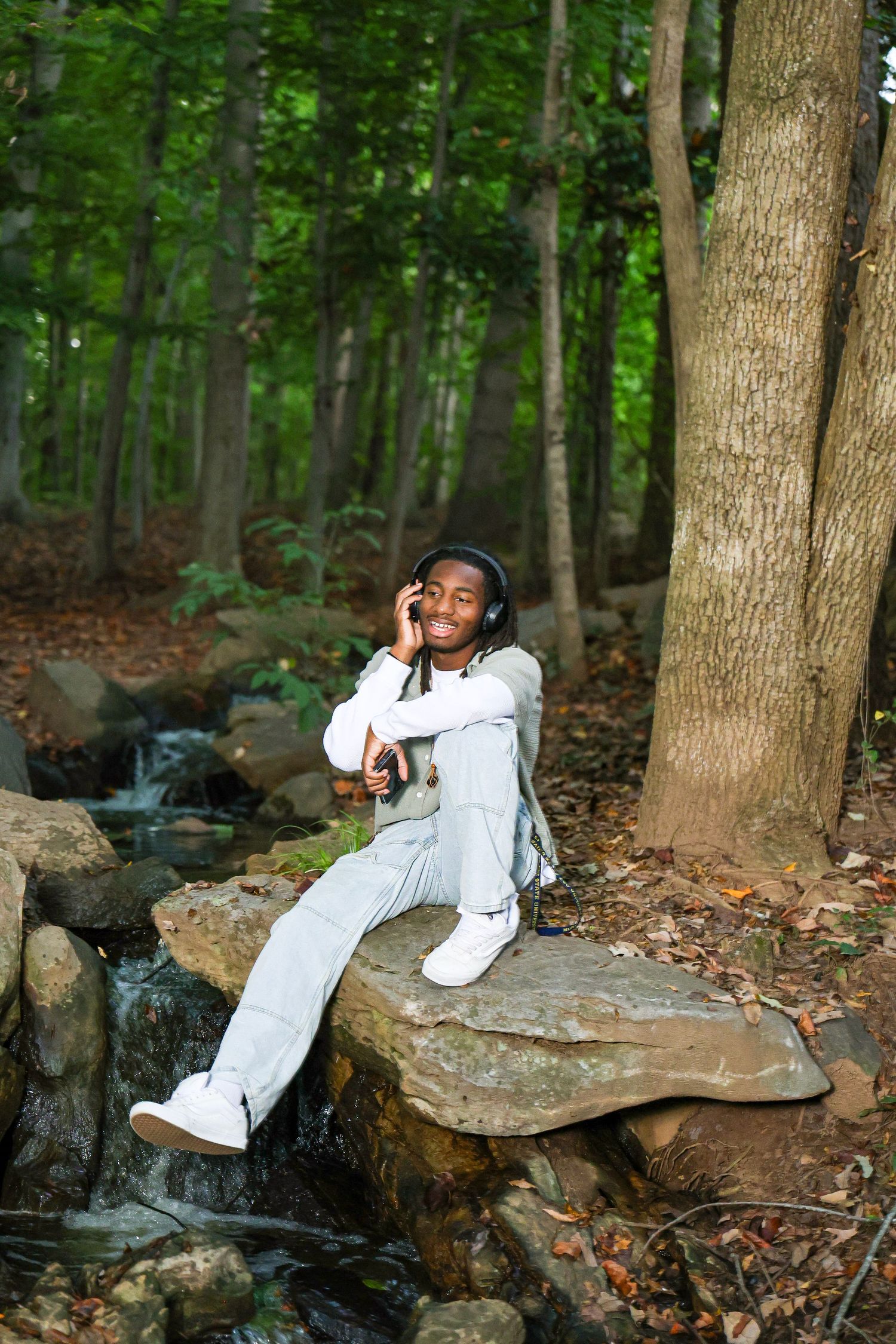 Natural outdoor photo session by a small waterfall in a wooded area.