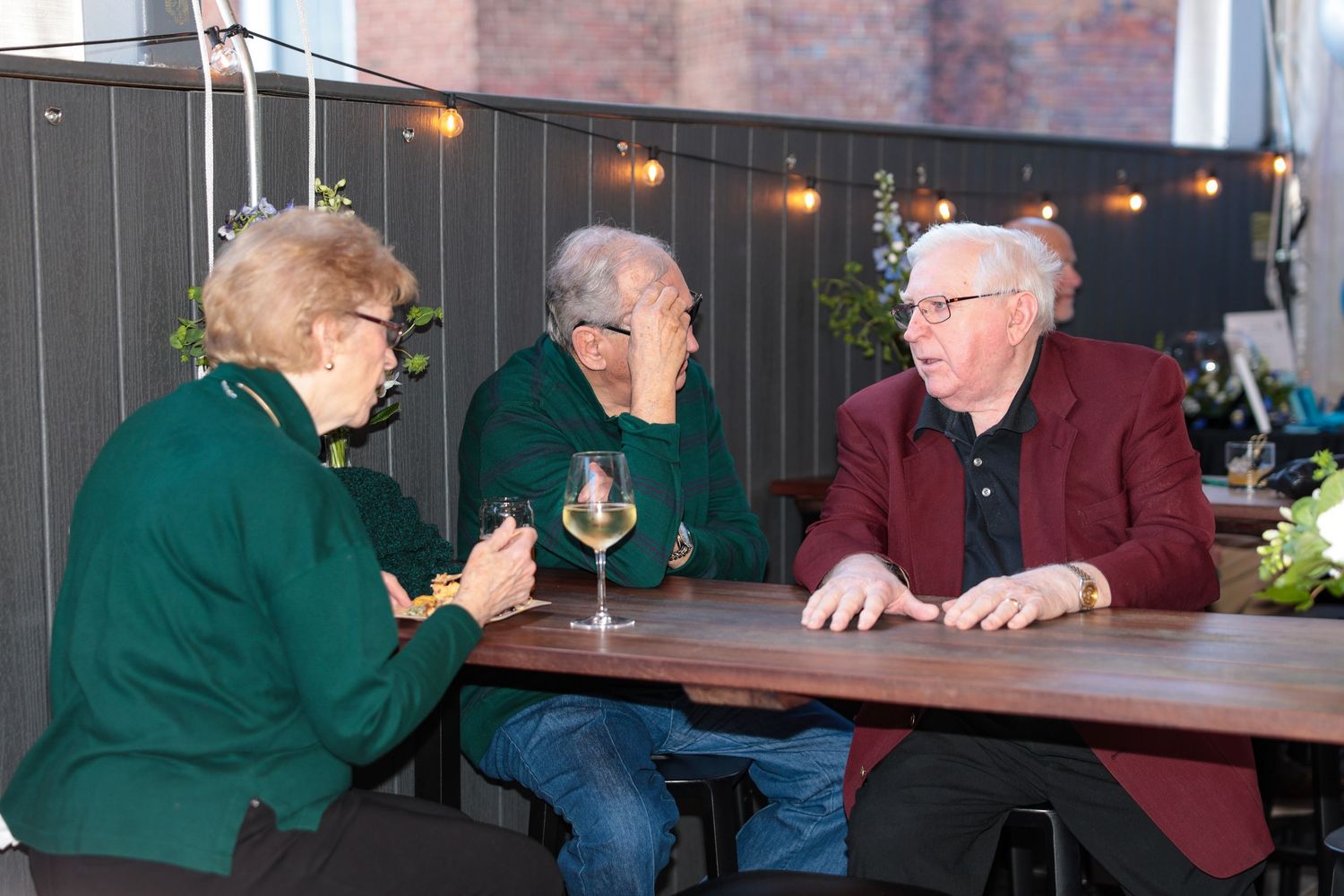 People gathered at a dimly lit restaurant table for an evening event.