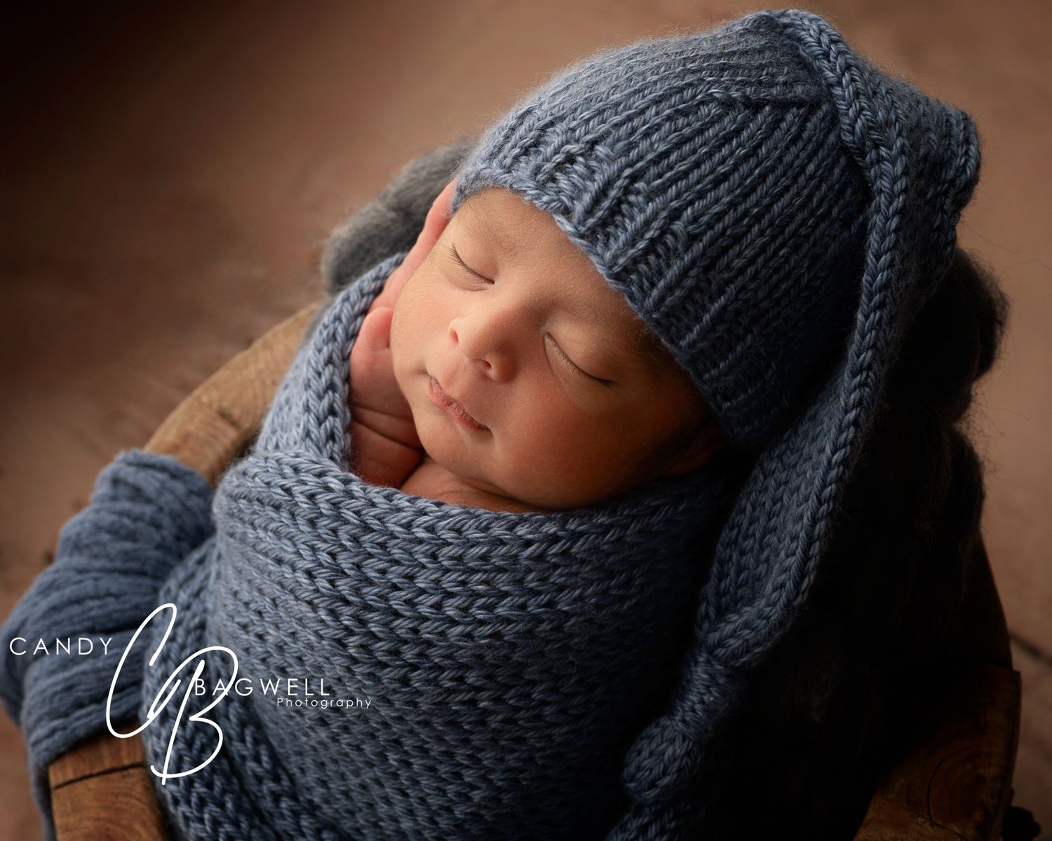 Cozy newborn portrait of a sleeping baby wrapped in blue by Candy Bagwell Photography, newborn photographer in Fletcher, NC.