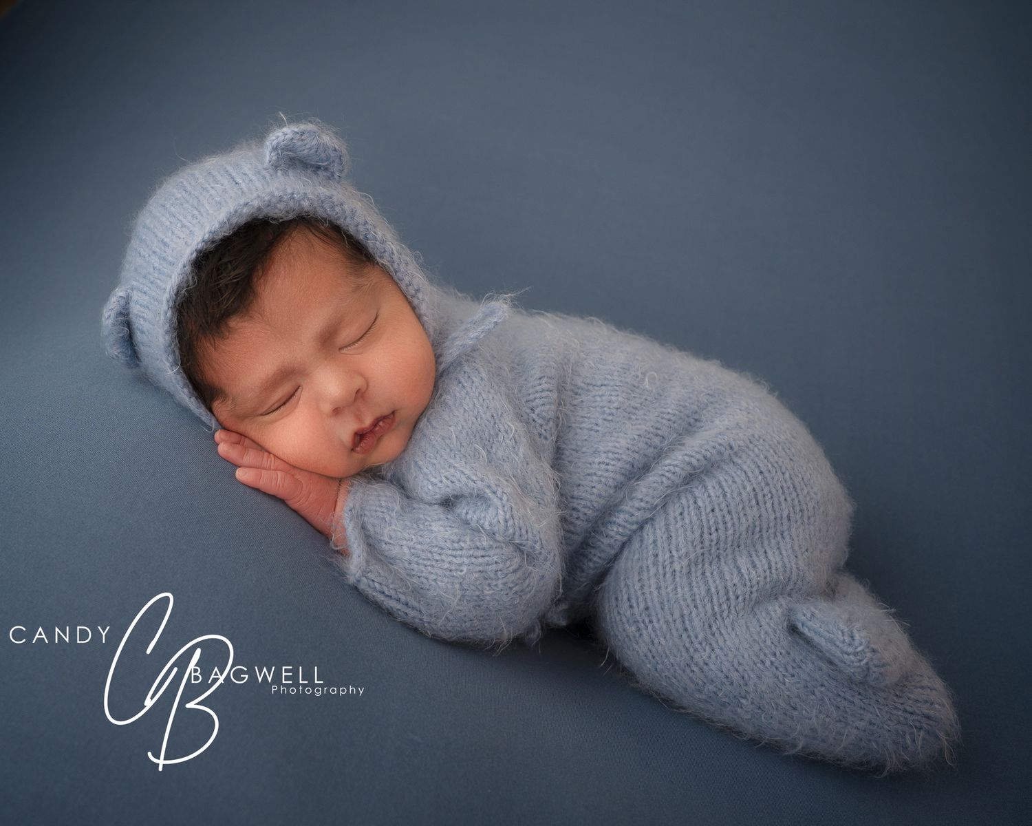 Posed newborn portrait of a sleeping baby in a soft blue outfit by Candy Bagwell Photography, newborn photographer in Fletcher, NC.