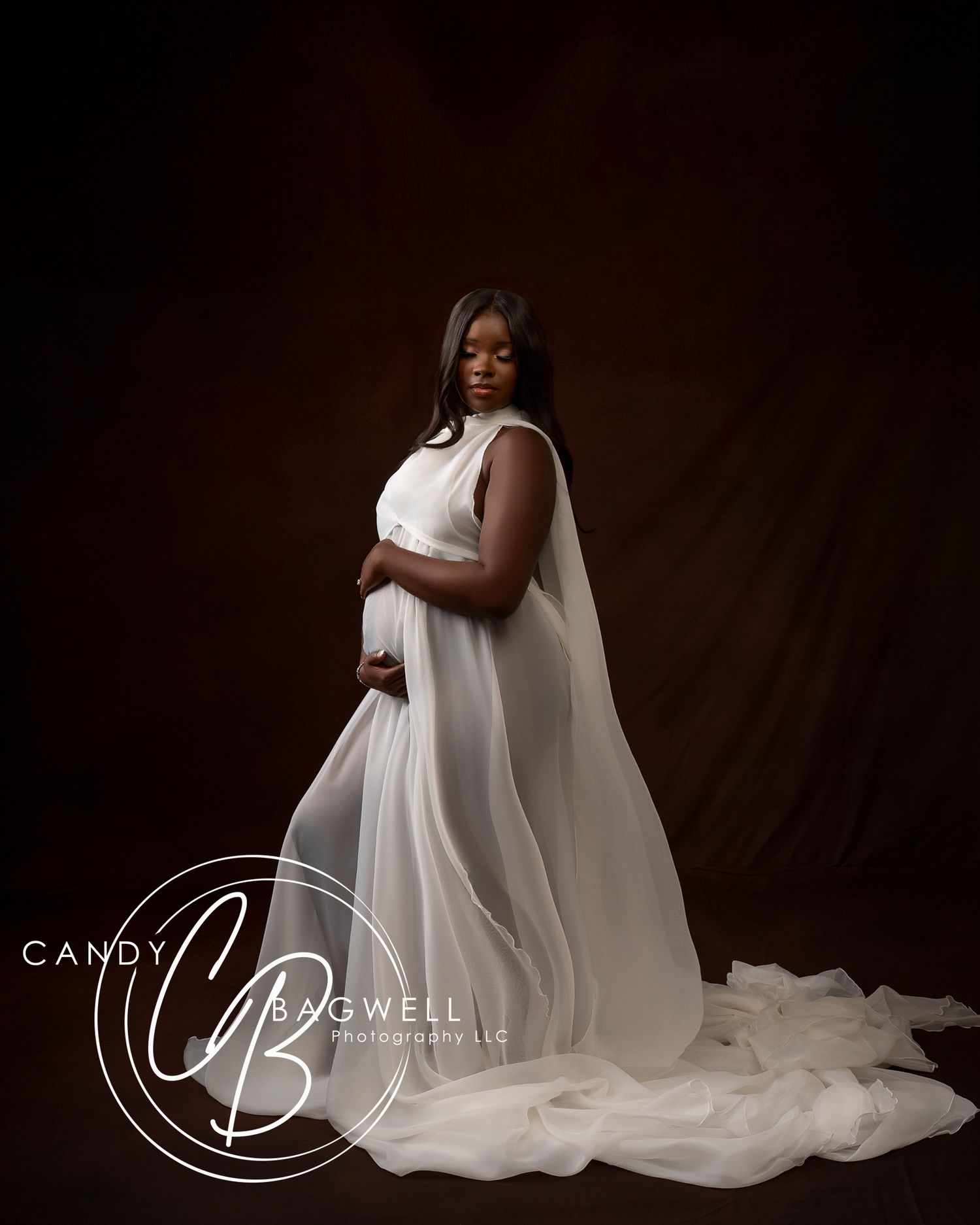 Luxury couples maternity portrait featuring a flowing white gown and dramatic studio styling by Candy Bagwell Photography in Fletcher, NC.
