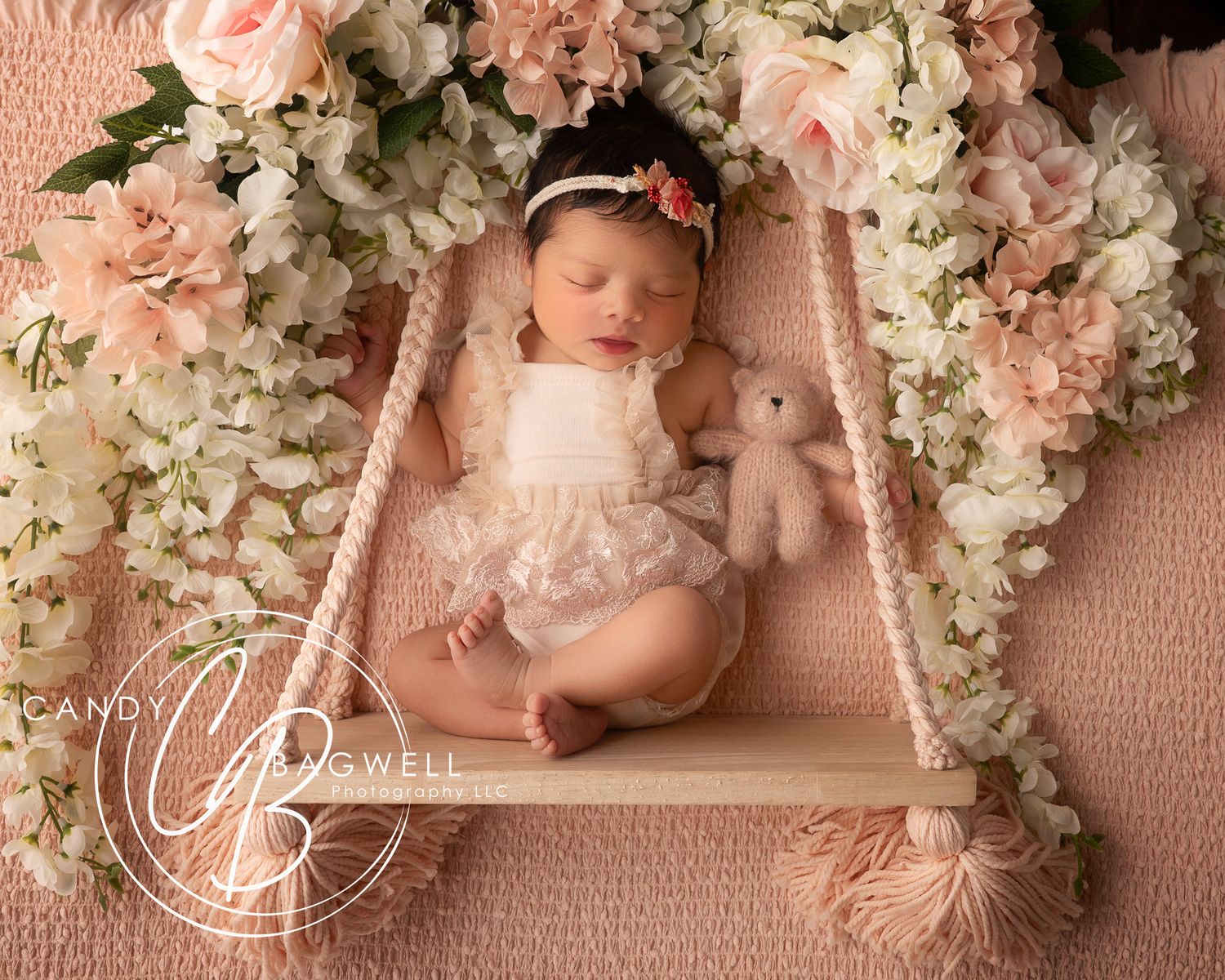 Newborn baby girl portrait surrounded by soft pink flowers and delicate styling by Candy Bagwell Photography in Fletcher, NC.