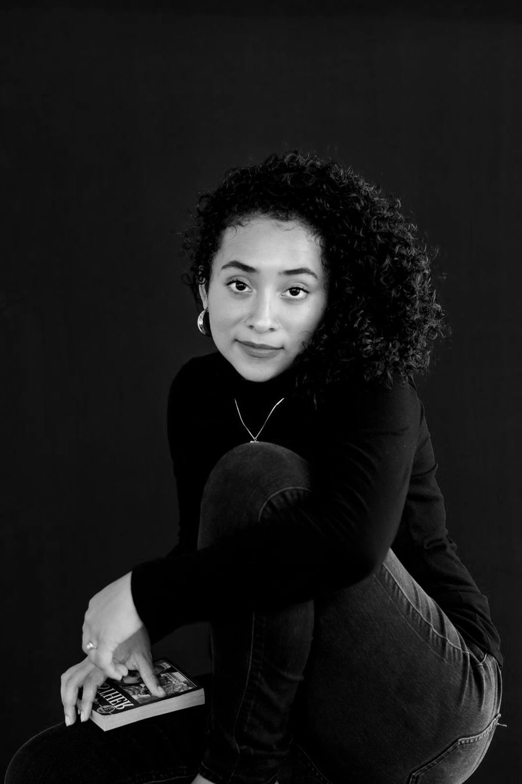 Black and white artistic portrait series showing a person in dark clothing against a dark background.