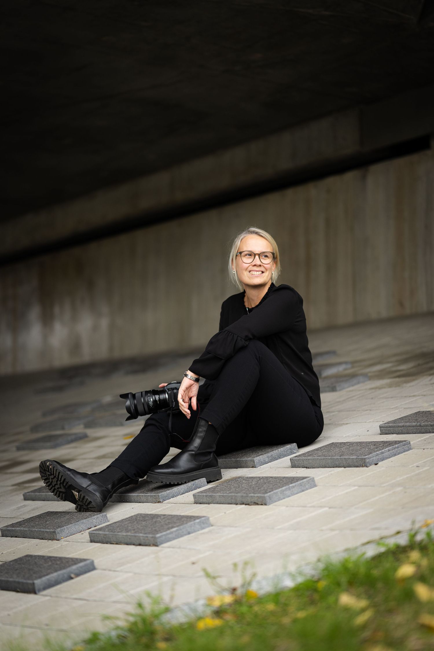 A sequence of artistic portrait photos showing someone reclining on concrete steps in a black outfit and glasses.