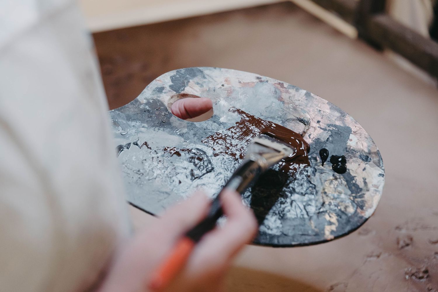 Hands working with clay on a pottery wheel, shaping and molding the wet material into a vessel.