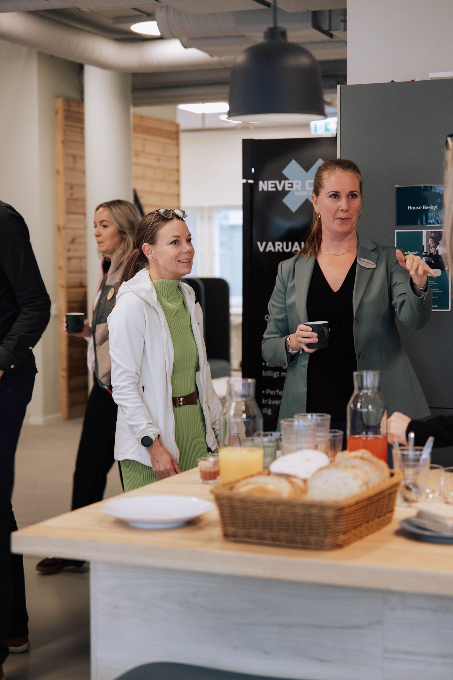 A series of photos showing people gathered around a modern kitchen counter during a casual office meeting or event.