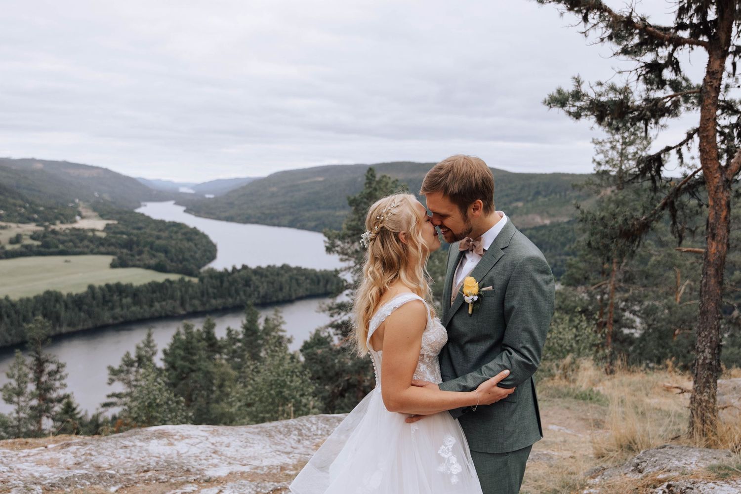 A couple shares romantic moments at various scenic mountain overlooks with a lake and forest landscape in the background.