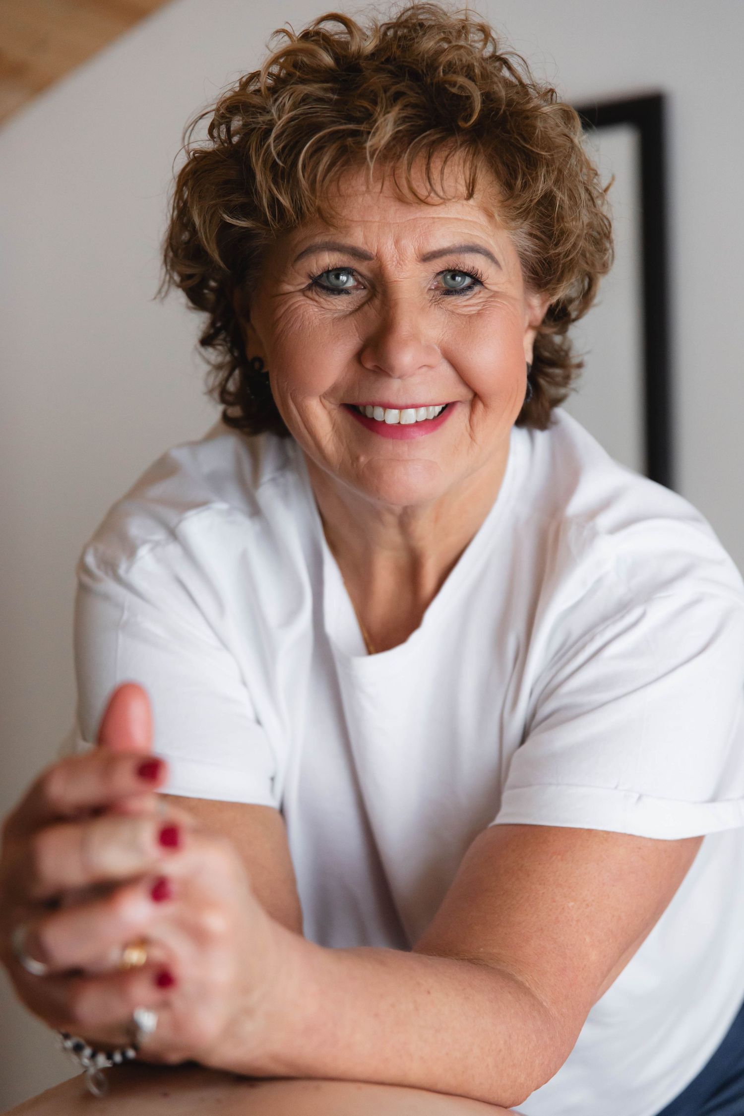 A series of portraits showing a person in a white shirt smiling warmly against a light background.
