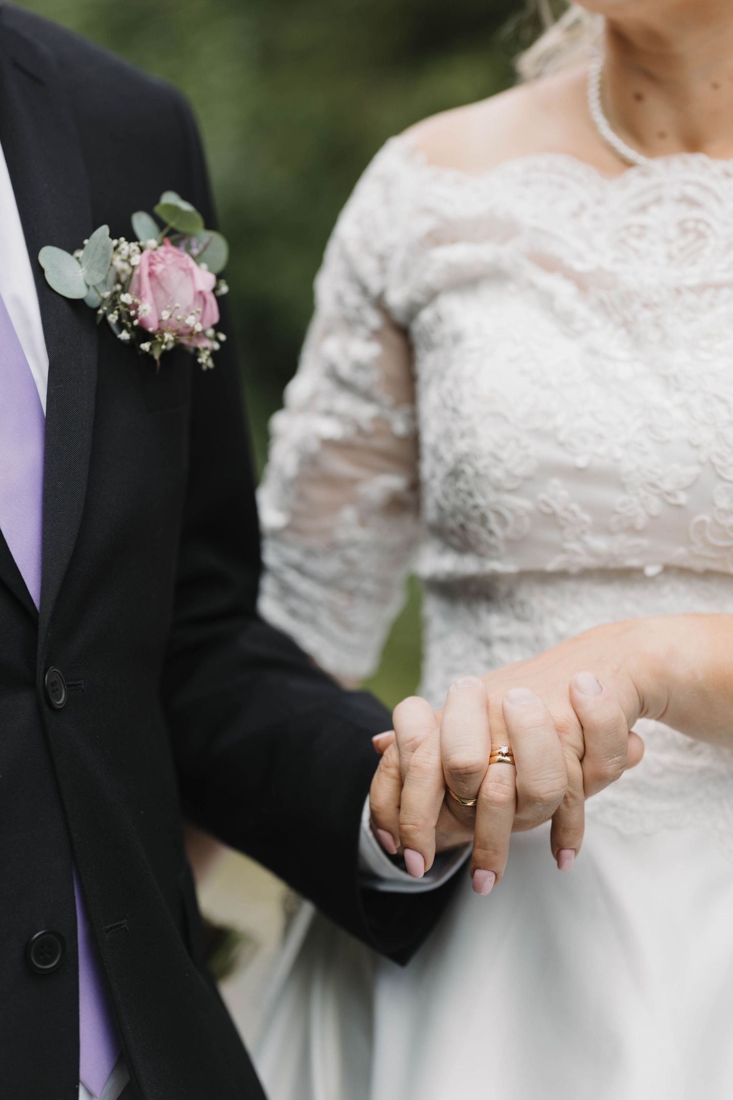 A series of close-up photos showing wedding rings and clasped hands in white lace and formal attire.