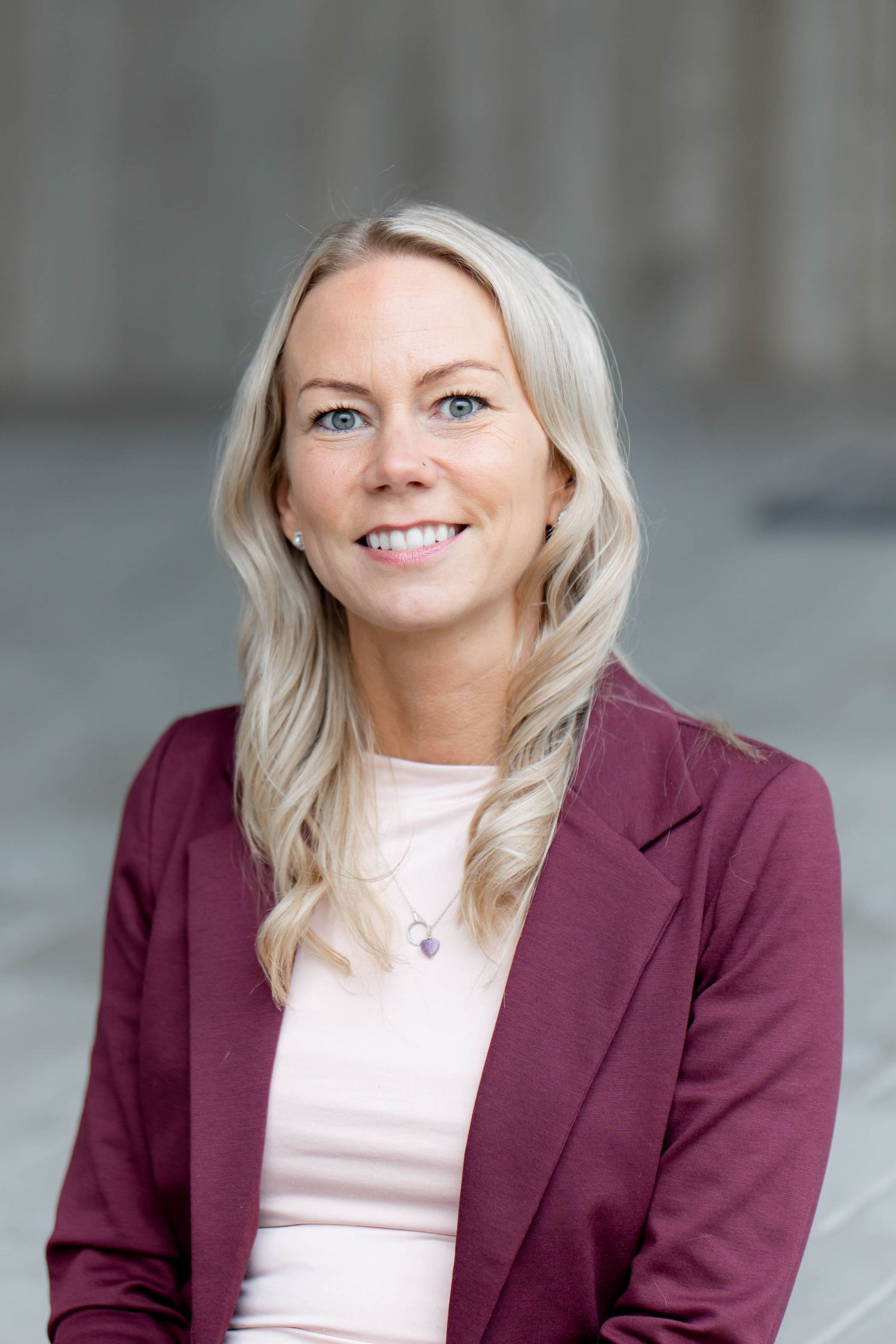 Professional headshots showing a person in a burgundy blazer and light top against a neutral background.