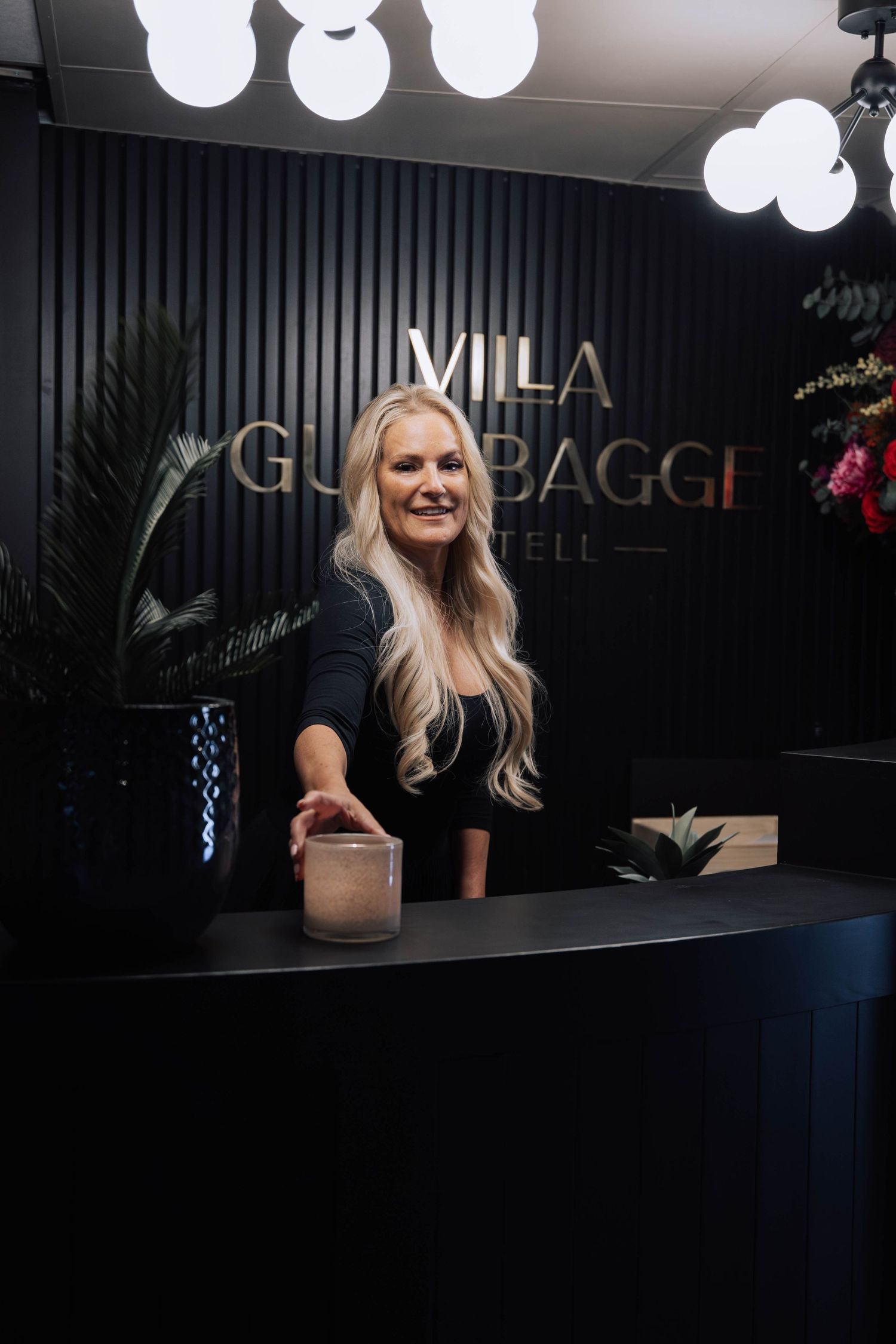 A dimly lit bar or restaurant interior with illuminated signage and dark decor creates a moody ambiance.