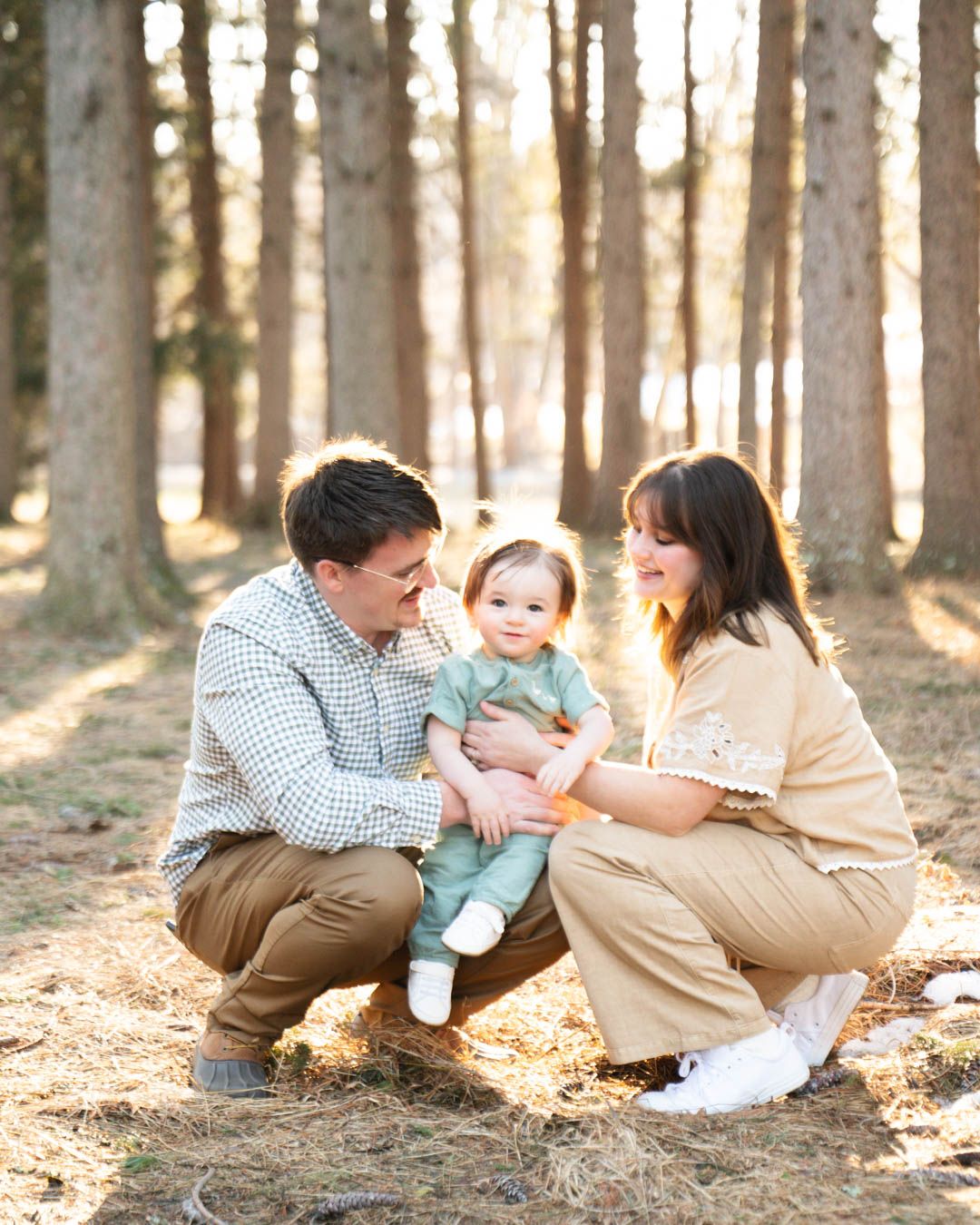 Mother and father kneeling down with toddler
