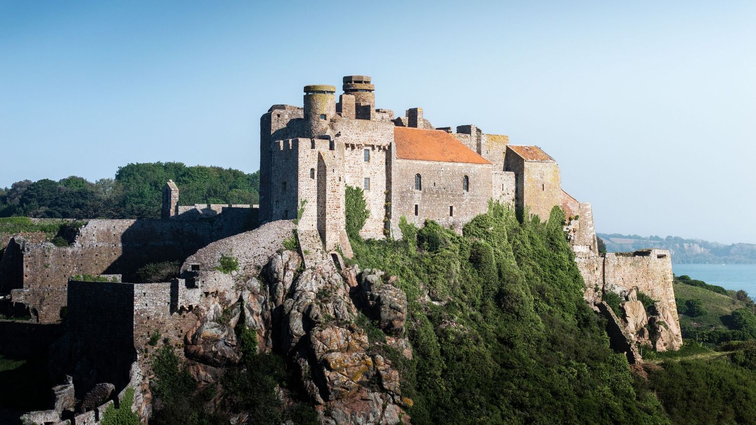 Historic castle fortress perched on coastal cliffs overlooking the ocean.