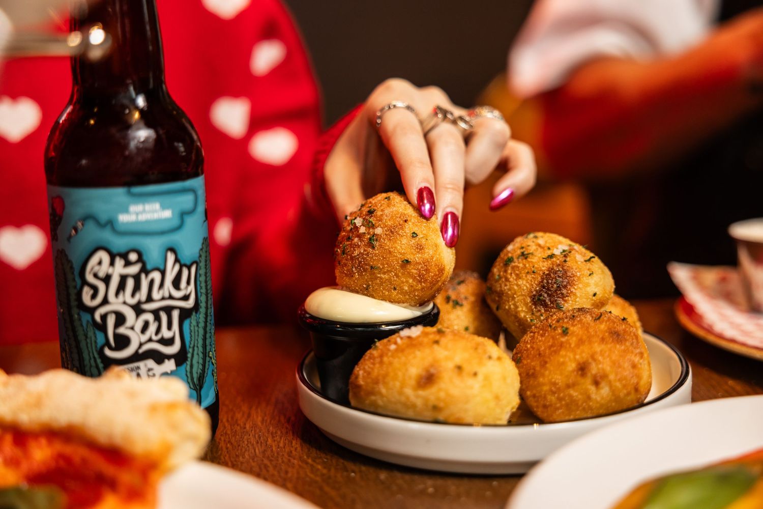 Fresh baked buns served on a plate next to a craft beer bottle.