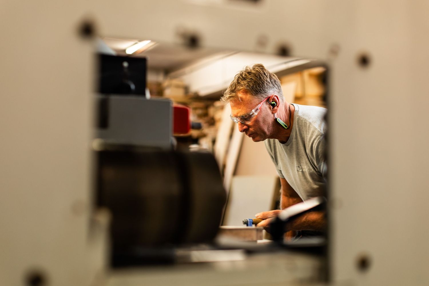 Woodworking professionals operating machinery in a workshop environment.